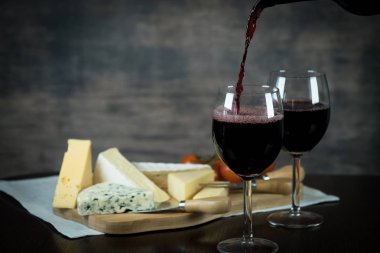 Ahşap arka planda üzüm ve şarap ile iştah açıcı peynir