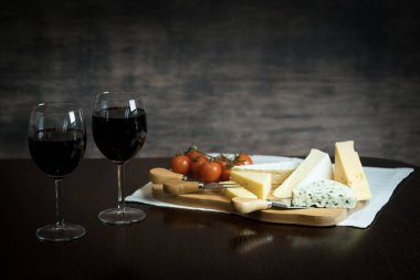 Appetizing cheese with grapes and wine on wooden background clipart