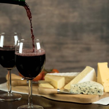 Ahşap arka planda üzüm ve şarap ile iştah açıcı peynir