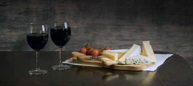 Ahşap arka planda üzüm ve şarap ile iştah açıcı peynir