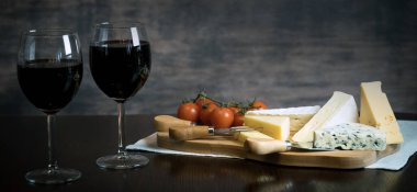 Ahşap arka planda üzüm ve şarap ile iştah açıcı peynir