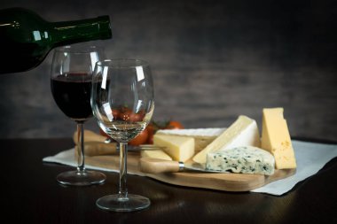 Ahşap arka planda üzüm ve şarap ile iştah açıcı peynir