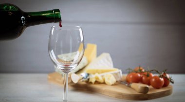 Ahşap arka planda üzüm ve şarap ile iştah açıcı peynir