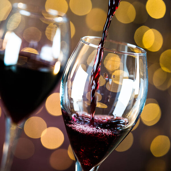 Бокалы для вина с бутылкой на фоне боке
