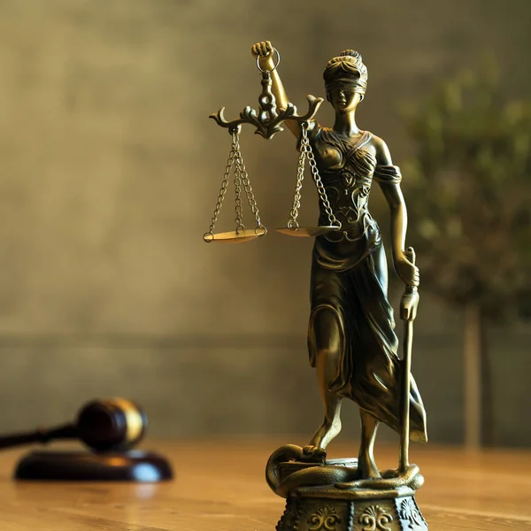 Kör tanrıça Themis heykeli ahşap masa üzerinde hakim toklak ile