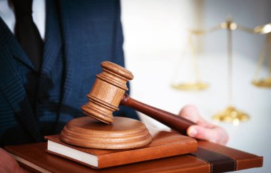 Yargıç tutarak, arka planda bulanık ölçekler.