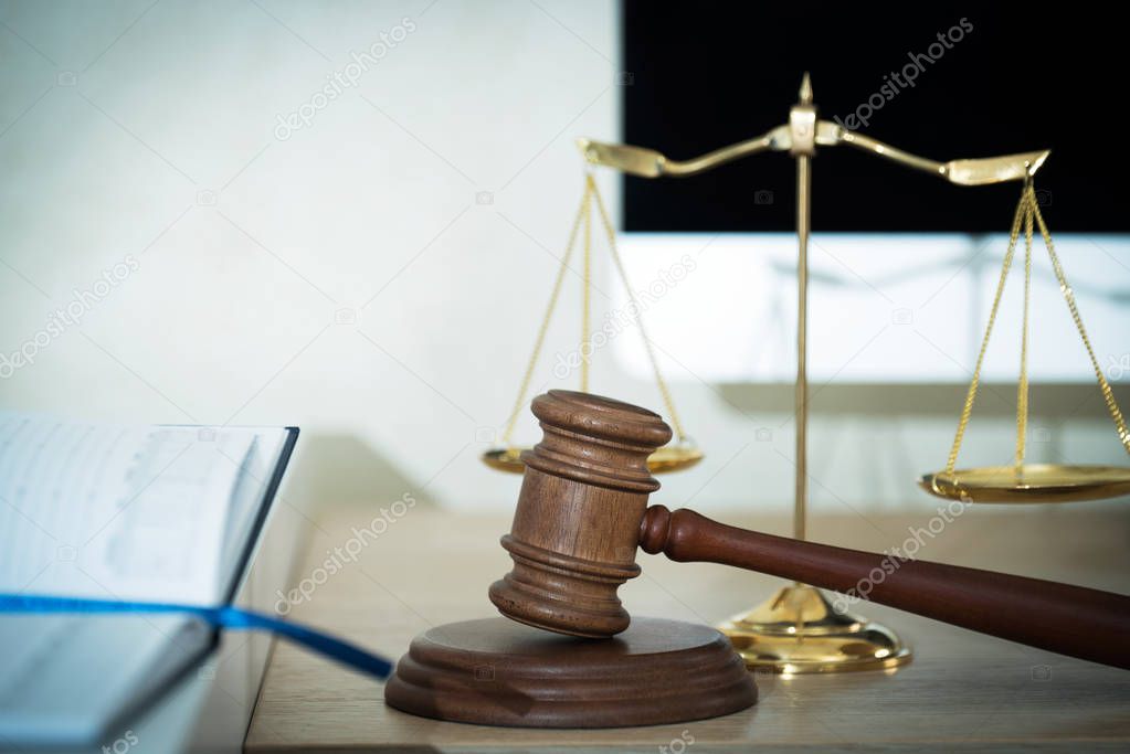 Law and Justice, judge gavel with scales on blurred background.