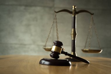Hukuk ve adalet, tahta masada ölçekler ile Yargıç tokmak.