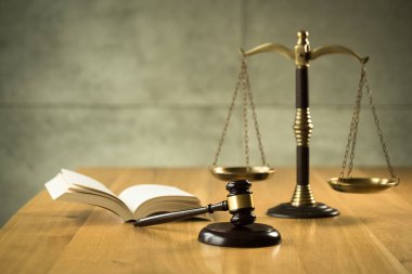 Hukuk ve Adalet, terazi ile yargıç tokarasında ve ahşap masa üzerinde kitap açtı.