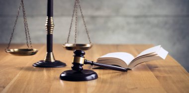 Hukuk ve Adalet, terazi ile yargıç tokarasında ve ahşap masa üzerinde kitap açtı.