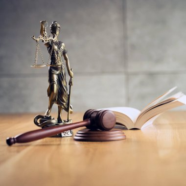 Hukuk ve Adalet, yargıç tokadı, ahşap masa üzerinde kör tanrıça Themis Heykeli ile kitap.