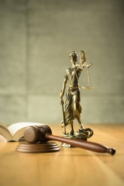 Hukuk ve Adalet, yargıç tokadı, ahşap masa üzerinde kör tanrıça Themis Heykeli ile kitap.
