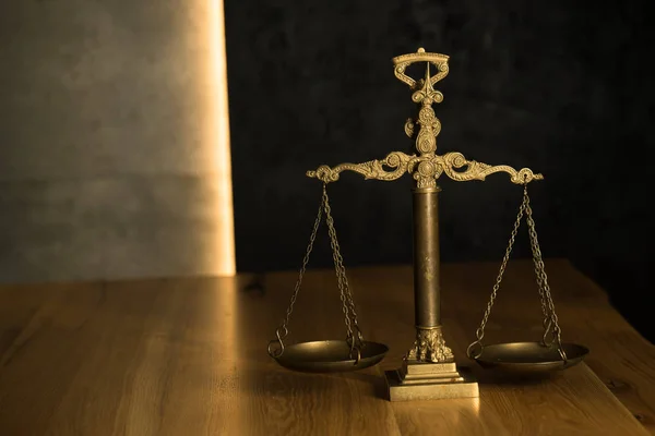 Law and Justice, scales on wooden table.