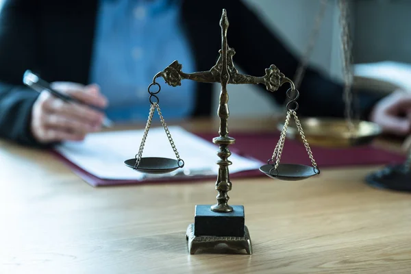 Judge working at table with symbols of law and justice on foreground