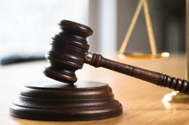 Hukuk ve Adalet, Yargıç tokmak ve teraziler ahşap masa ve bulanık arka plan.