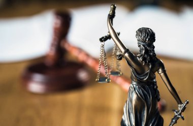Hukuk ve Adalet, kör tanrıça Themis 'in heykeli ahşap masanın üzerinde bulanık arka planda..