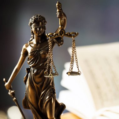 Hukuk ve Adalet, kör tanrıça Themis 'in heykeli ahşap masanın üzerinde bulanık arka planda..