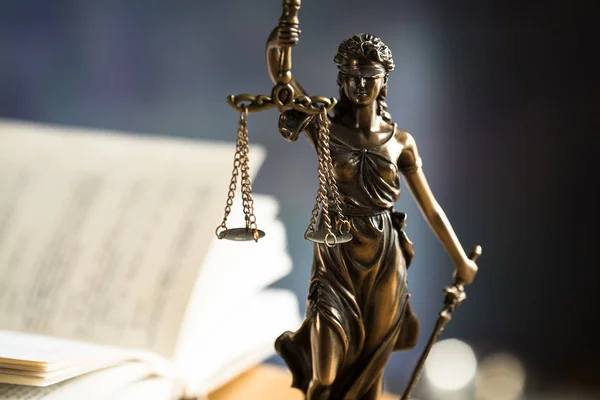 Law and Justice, Statue of blind goddess Themis on wooden table with blurred background.