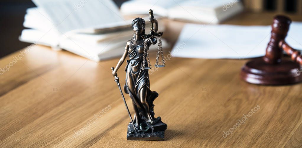 Law and Justice, Statue of blind goddess Themis on wooden table with blurred background.