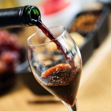 Arka planda aperatifler olan kırmızı şaraba yakın çekim