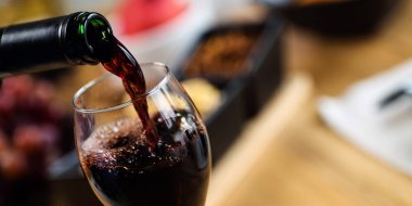 Arka planda aperatifler olan kırmızı şaraba yakın çekim