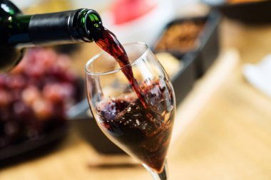 Arka planda aperatifler olan kırmızı şaraba yakın çekim