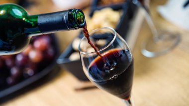 Arka planda aperatifler olan kırmızı şaraba yakın çekim