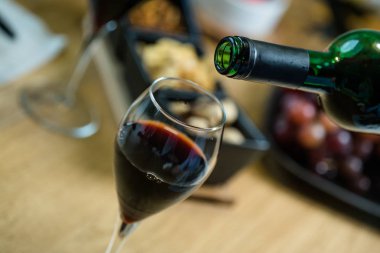 Arka planda aperatifler olan kırmızı şaraba yakın çekim