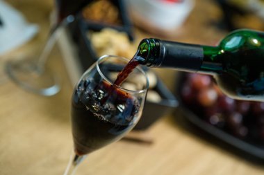 Arka planda aperatifler olan kırmızı şaraba yakın çekim