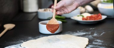 Evde pizza hazırlayan kadın.