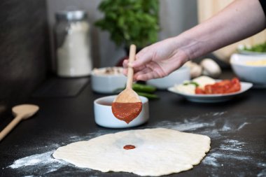 Evde pizza hazırlayan kadın.