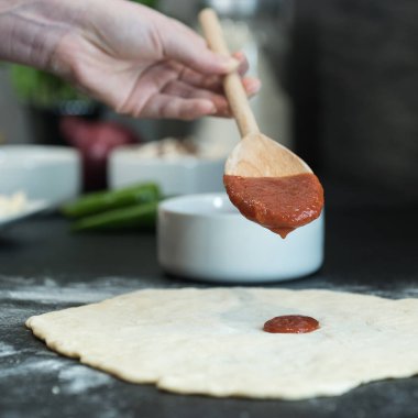 Evde pizza hazırlayan kadın.