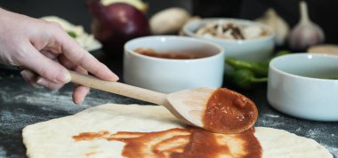 Evde pizza hazırlayan kadın.