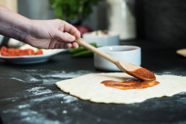 Evde pizza hazırlayan kadın.