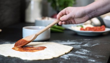 Evde pizza hazırlayan kadın.