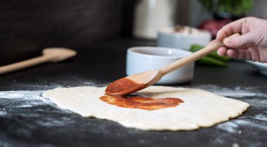 Evde pizza hazırlayan kadın.