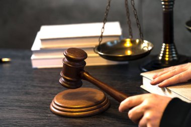 Yargıç, hukuk ve adalet sembolleriyle masada çalışıyor.