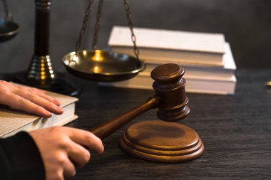Yargıç, hukuk ve adalet sembolleriyle masada çalışıyor.