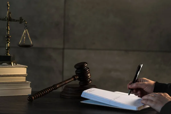 Judge working at table with symbols of law and justice