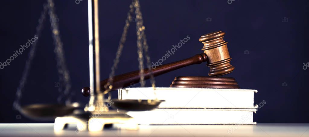 Law and Justice symbols on wooden table with blurred books background.