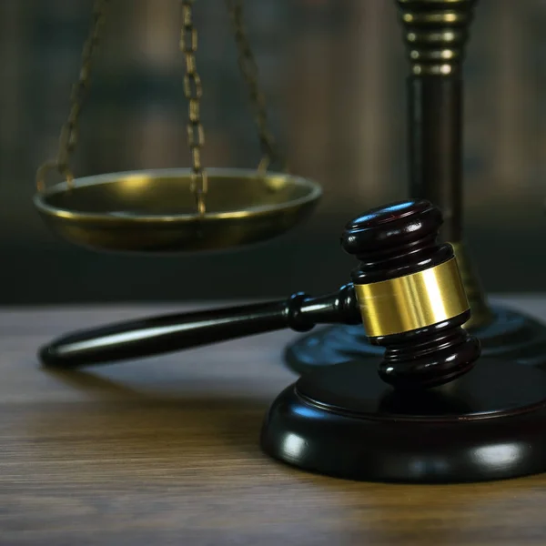 背景がぼやけた木のテーブルの上の法律と正義のシンボル — ストック写真