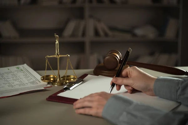 Judge working at table with symbols of law and justice