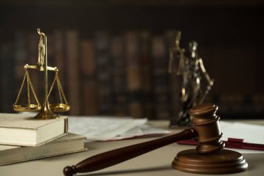 Ahşap masa arkasında hukuk ve adalet sembolleri..