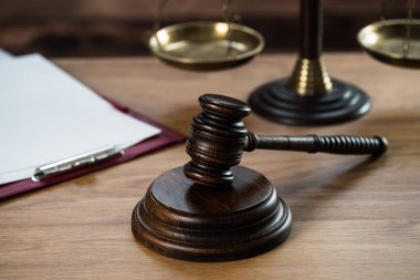 Ahşap masa arkasında hukuk ve adalet sembolleri..