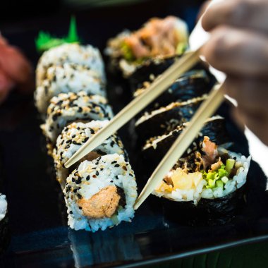 Taze Japon suşi böreği yiyen kişi, popüler Asya yemekleri..