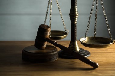 Ahşap masa arkasında hukuk ve adalet sembolleri..