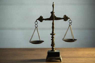 Hukuk ve Adalet 'in hayatı hâlâ devam ediyor. Ahşap masa arkasında pullar var..