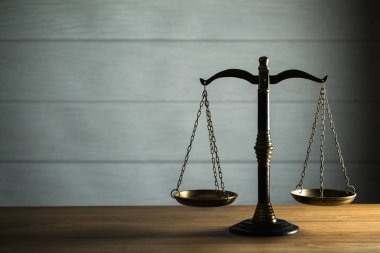 Hukuk ve Adalet 'in hayatı hâlâ devam ediyor. Ahşap masa arkasında pullar var..