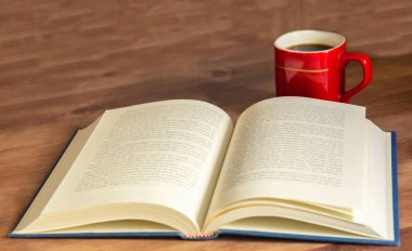 Ahşap arka plan üzerinde kahve fincan ı ile açık kitap.