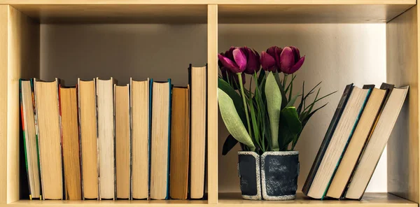 Pile of closed books on wooden shelf